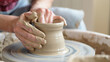 © olgakris - Hands shaping wet clay on a spinning pottery wheel, close-up craft process in a ceramics studio, wheel throwing technique, vessel formation, texture, mindfulness, traditional craftsmanship