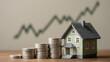 © Imagehub - Miniature house with increasing stacks of coins and an upward trend graph, symbolizing growing real estate investment, property value, and financial prosperity.
