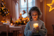 © Halfpoint - Small girl with santas hat during Christmas, holding candle.