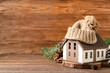 © Pixel-Shot - Winter composition with decorative house, forest bumps, hat and fir tree branches on brown wooden background