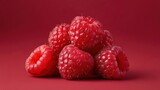 Fresh raspberries close up on a vibrant red background for culinary and design inspiration