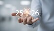 © Tama - A person's hand holding a glowing lightbulb with numbers 25 and 26, symbolizing ideas.