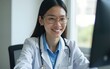 © Dorothy - An Asian female doctor sits at her desk, conducting an online consultation. This faster, cheaper, and more convenient method helps prevent disease spread and offers easier access to healthcare.