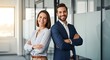 © youns - Retrato de pancarta de un líder latino o indio maduro sonriente y una mujer europea segura de sí misma de pie con los brazos cruzados en el cargo. Dos colegas diversos, equipo de grupo de empresarios