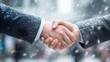 © Andrey - Close-up of two businessmen shaking hands in winter, corporate partnership agreement, snowy city background, successful deal concept, professional meeting