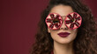 © pecherskiydotkz - Intense, artful portrait of a Middle Eastern woman wearing pomegranate slice glasses against a rich burgundy backdrop, blending sensual beauty with bold, jewel-toned creativity.