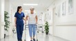 © QuiinL - Caring female nurse or caregiver helping a senior woman walk with a walker down a bright hospital hallway.