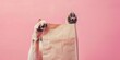 © Loktor - Perrito pequeño con mockup bolsa de papel sobre fondo rosa, promoción tienda de mascota, perro feliz con bolsa de papel con espacio para copy