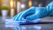 © Luba - Hand in Blue Glove Cleaning Surface with Microfiber Cloth