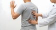 © arya - Doctor examining patient's back for pain relief and improved spinal health in clinical setting, offering healthcare solutions for wellness