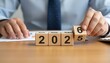 © Husen - Wooden blocks showing the year 2026 being built by a businessman.