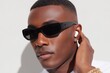 © World of AI - Stylish young man wearing futuristic sunglasses and wireless earbuds poses confidently against a light background, showcasing modern fashion and urban lifestyle with a touch of sophistication