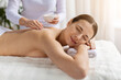 © Anastasiya - Young woman enjoying back massage while therapist applies exfoliating salt. Warm tones, gentle focus and soft texture highlight beauty care, skincare and deeply soothing spa treatment experience