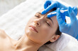 © Anastasiya - Young female receiving forehead cosmetic injection at spa clinic. Relaxed expression, gloved precision and sterile tools emphasize professional medical aesthetics and beauty rejuvenation