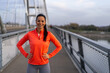 © Creative Light - Smiling woman in activewear poses confidently on a bridge