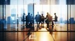 © Ka Ab - Blurred silhouettes of business professionals engaged in a meeting within an expansive modern