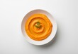 © Meow Creations - Bright orange carrot hummus with olive oil swirl and fresh dill sprig on white