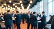 © Mostofa - Blurred image of people in suits at a business conference or networking event