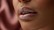 © Fitra - Sensual close-up of a woman's lips adorned with shimmering glitter lip gloss, creating a glamorous and radiant beauty statement