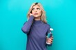 © luismolinero - Young Russian woman with a bottle of water isolated on blue background frustrated and covering ears