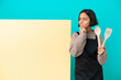 © luismolinero - Young mixed race cook woman with a big placard isolated on blue background having doubts while looking up