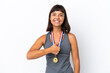 © luismolinero - Young mixed race woman with medals isolated on white background giving a thumbs up gesture