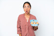 © luismolinero - Young hispanic woman holding eggs isolated on white background looking up and with surprised expression