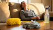 © zamuruev - Woman rests on couch after cleaning with duster and spray bottle nearby. Sunlight streams through window, creating warm atmosphere. Concept of home care, relaxation, wellness