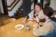 © 4Max - Two women sharing a meal at home kitchen table
