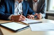 © starush - Business meeting with professionals signing important documents at a desk