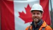 © Pete - Smiling Canadian man wears hard hat, safety jacket for work. Happy worker in construction industry, engineer shows confidence. Male person pride, stands against national Canada flag background.