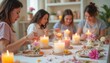 © Pete - Women create floral infused candles in workshop. Friends learn candle making craft, decorating jars with flowers. Relaxing hobby activity session.