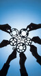 © Tahmina - Hands connecting metal gears against a bright blue sky, symbolizing teamwork and synergy.