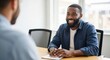 © David - A friendly and confident young professional man with a beard smiling happily while listening during a business meeting or job interview in a modern, sunlit office