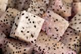 diced ripe red pitaya with lots of small black seeds and white sweet flesh inside, sweet ripe dragon fruit with black small seeds and light flesh cut in half into small cubes