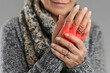 © Gonzalo - Close-up of an elderly woman’s hands with one hand gripping the other in pain, showing red inflammation, possibly due to arthritis or joint pain.