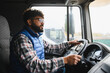 © Serhii - Truck driver steering vehicle on job