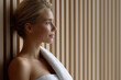 © vejaa - Beautiful young woman in towel relaxing in wooden sauna spa
