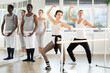© JackF - Graceful women and sports men practice at ballet standing at barre in choreography studio