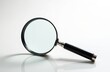 © Pete - Magnifying glass with black handle on white background. Tool for close examination observation inspection and discovery. Focus on detail accuracy and precision.