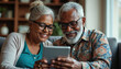 © Pete - Happy senior couple reviews financial info on tablet. Smiling elderly people at home look at investment plan retirement funds. Happy old age with tech.