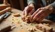 © Pete - Hands work on wooden toy car. Craftsman smooths wood with sandpaper. Tools and shavings lie on table. Skillful hobbyist makes miniature vehicle.