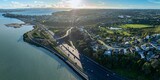 Aerial view of Auckland, New Zealand, showing the Upper Harbour Motorway bridge. Cars travel along the highway, connecting communities and facilitating transportation. Onepoto Domain.
