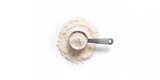 Top view of wheat flour in a measuring cup on white background, used for baking preparation