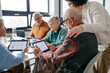 © Halfpoint - Group of senior people learning digital skills with tutor help.