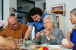 © Halfpoint - Group of senior people learning knitting together with caregiver tutor in a community center.