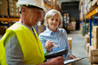 © Halfpoint - Senior woman manager and man worker working in a warehouse.