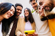 © Xavier Lorenzo - Happy group of people using having fun using mobile phone at city street. Social media and youth concept