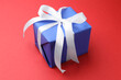 © New Africa - Beautiful gift box on red background, closeup