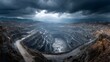 © horizon - Dramatic, wide-angle aerial shot of a vast open-pit mine. The terraced levels and industrial infrastructure are seen under a moody, overcast sky.